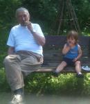Dziadek i Tymon jedzą kiszone ogórki w ogrodzie. Legionowo, Lipiec 2013.